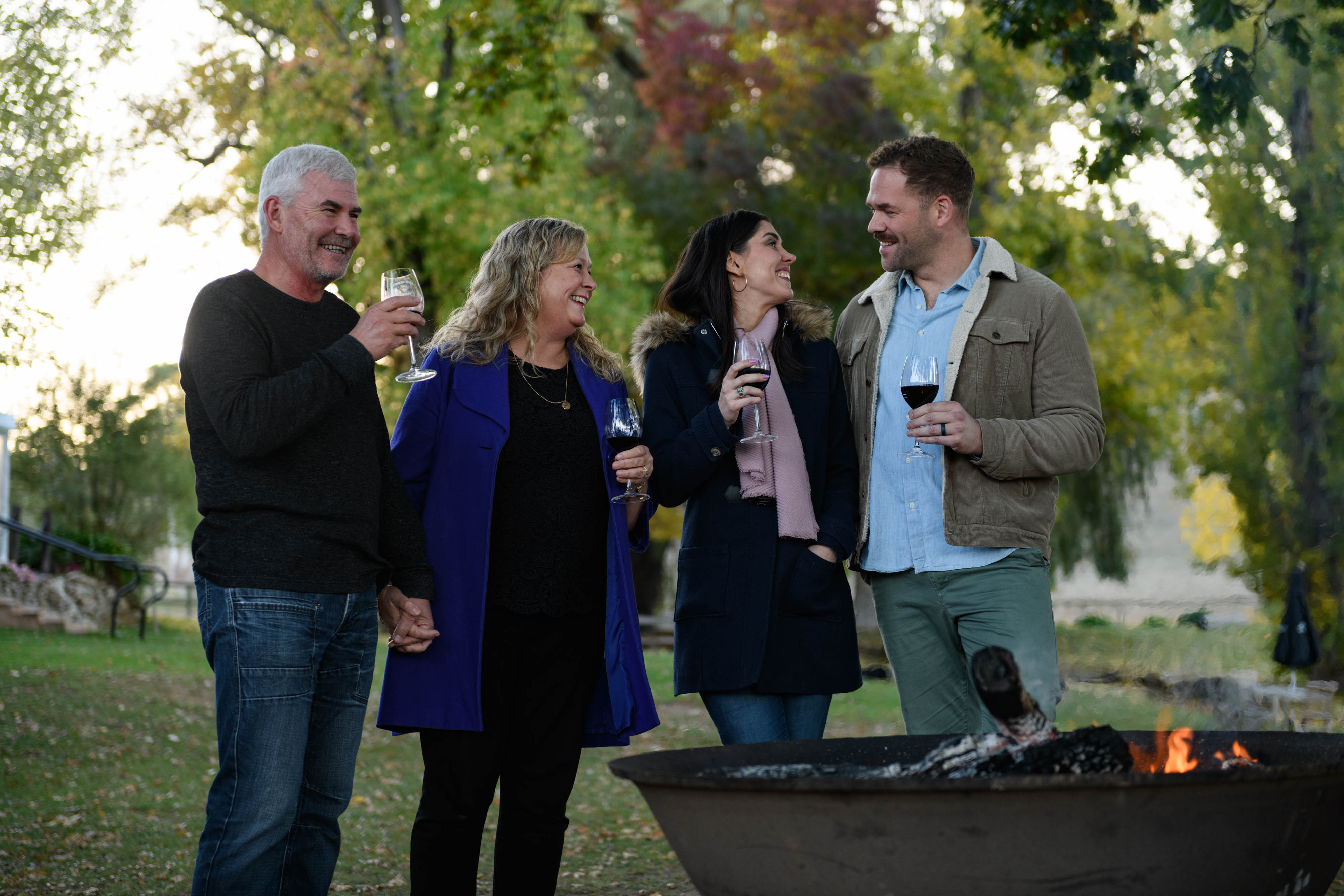 People enjoying wine by the firepit 